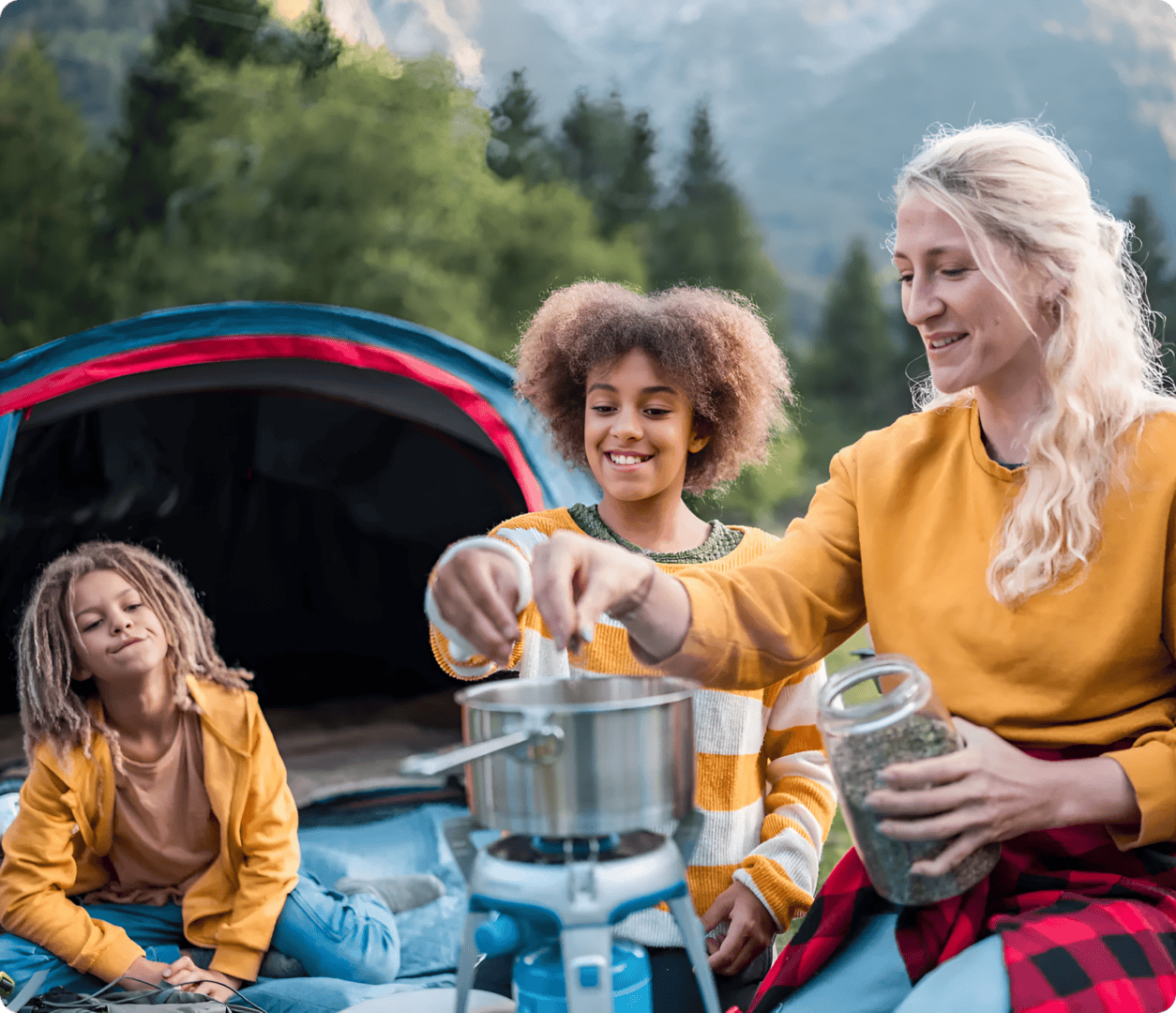 Family enjoying camping breakfast outdoors in nature.