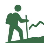 Silhouette of a hiker climbing a slope with a walking stick.